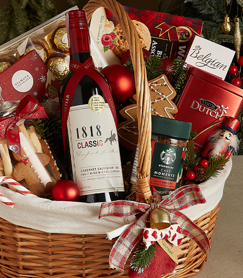 Woven wicker Christmas wine gift basket with Cabernet Sauvignon, artisan chocolates, coffee, gingerbread, and festive