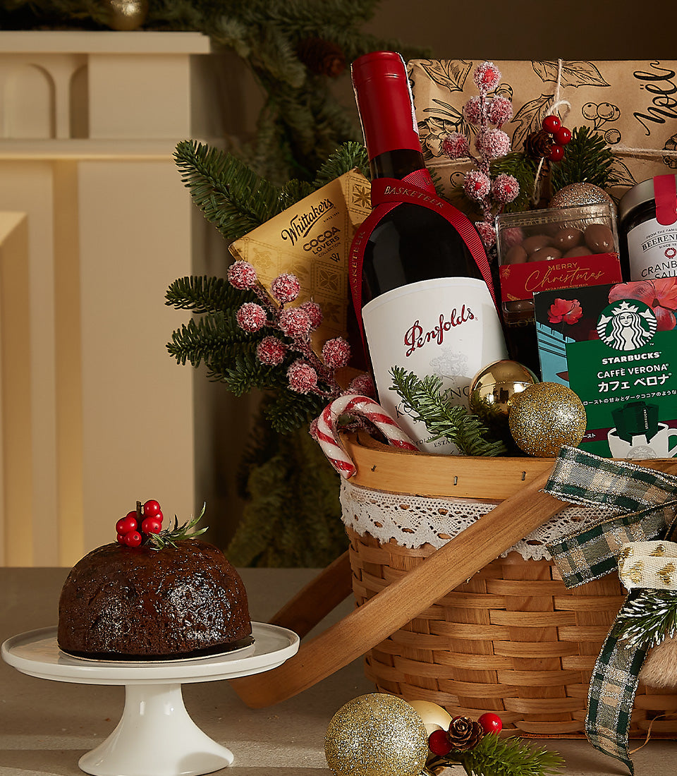 Woven Christmas gift basket with red wine, chocolates, nuts, and festive holiday treats