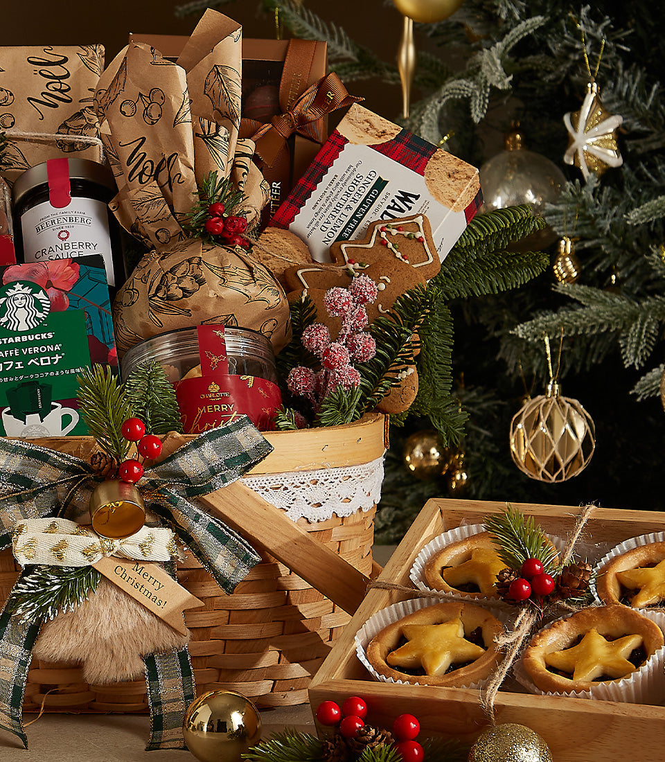 Woven Christmas gift basket with red wines, gourmet coffee, cranberry sauce, shortbread, and festive treats plus star-shaped