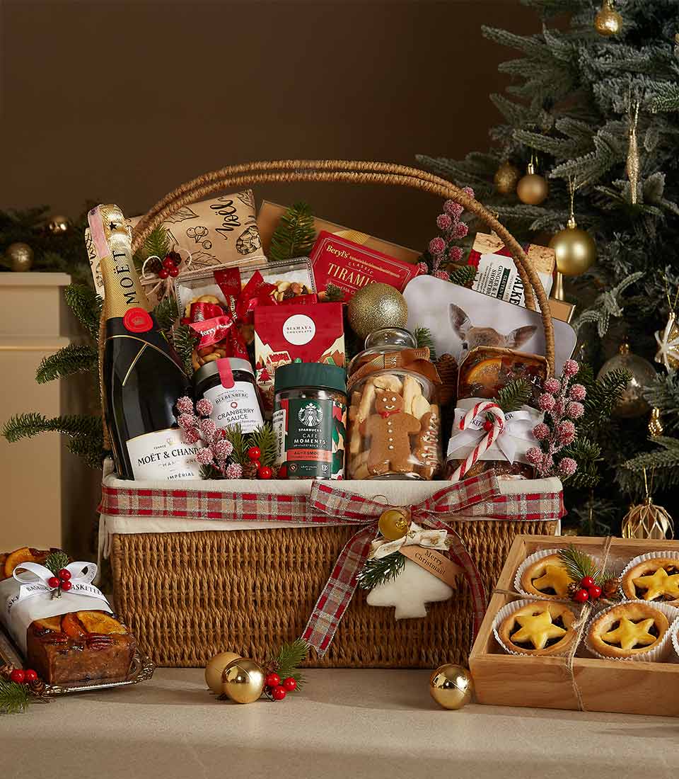 Luxury Christmas hamper with champagne, gourmet treats, and woven wicker basket tied with plaid ribbon