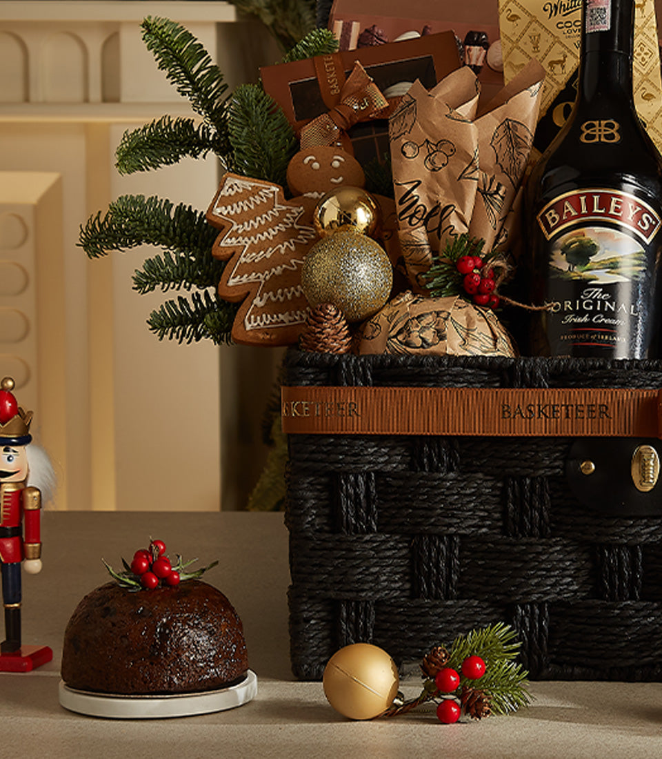 Premium black woven Christmas hamper with Baileys, gingerbread cookies, gold ornaments, and festive treats