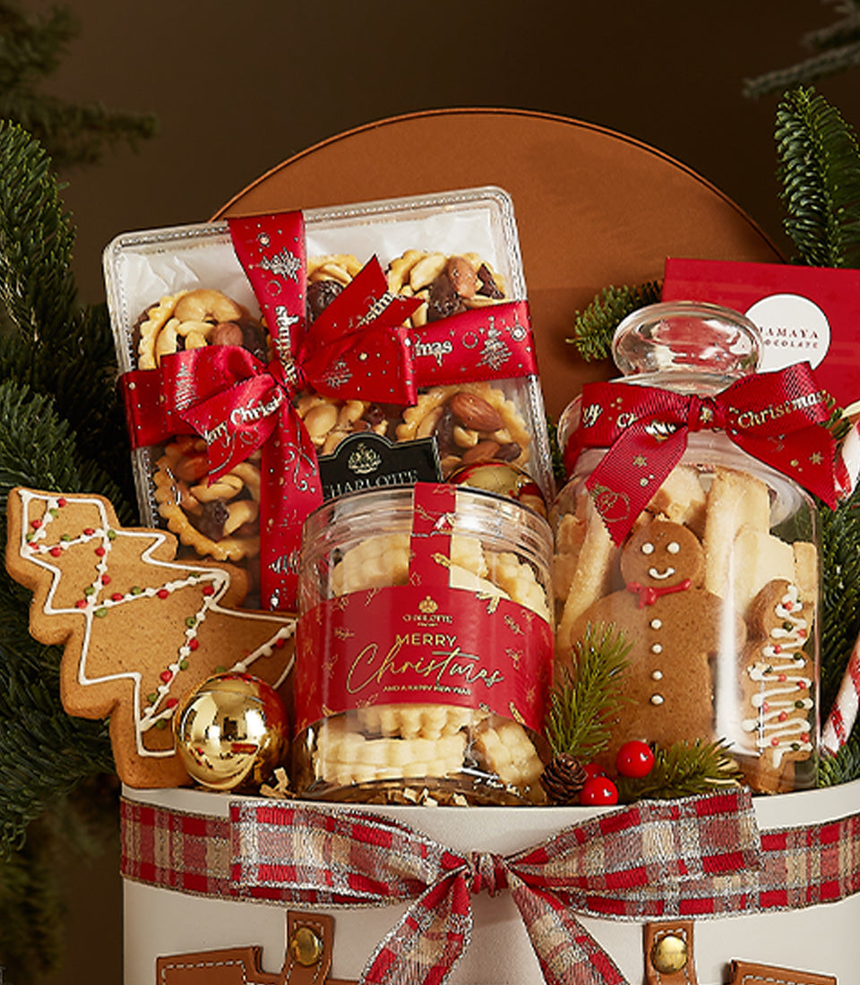 Festive white Christmas treat box with gourmet tarts, cookies, and gingerbread in clear jars, red ribbons, and plaid bow