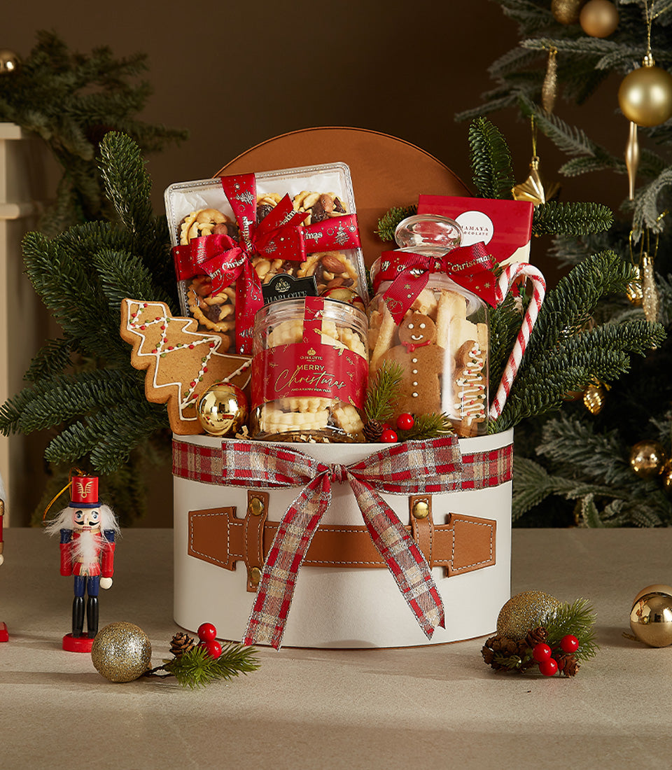 Festive white Christmas treat box with plaid ribbon, gourmet baked goods, and holiday decorations