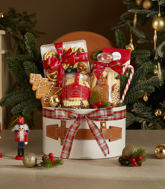 Festive white Christmas treat box with plaid ribbon, gourmet baked goods, and holiday decorations