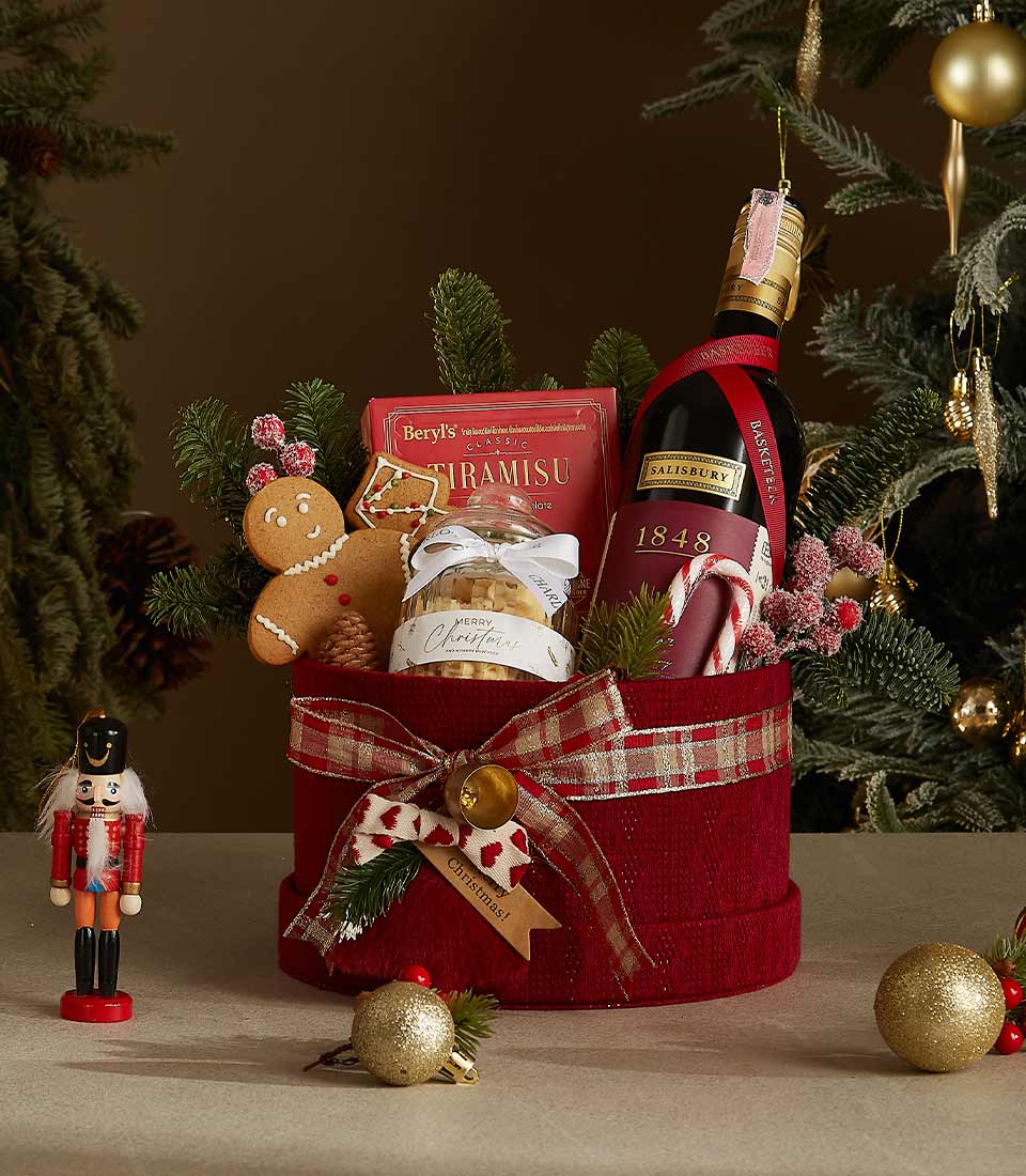 Festive red velvet Christmas gift box with red wine, tiramisu chocolates, cookies, and gingerbread treats