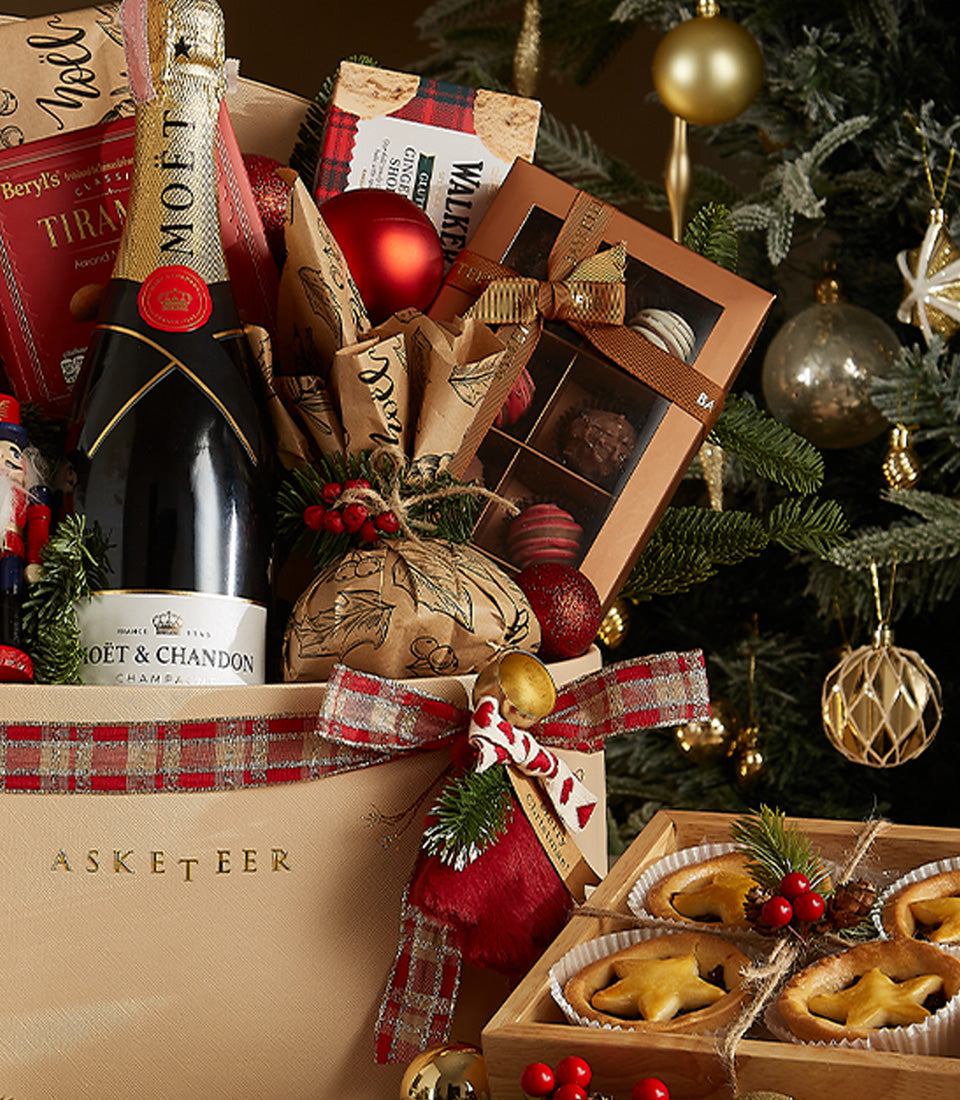 Luxury Christmas champagne gift hamper with Moët & Chandon, gourmet chocolates, shortbread, and festive decorations in