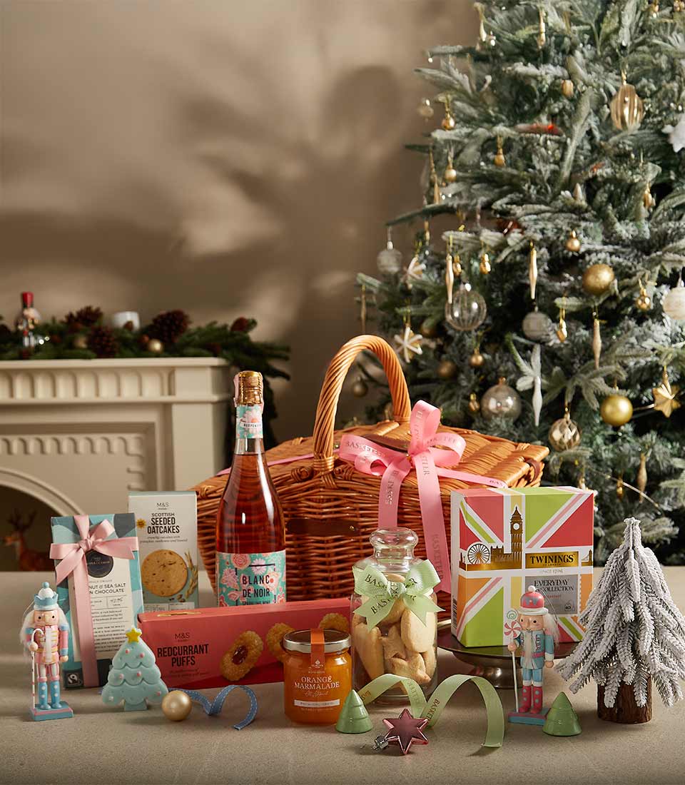 Festive tea and treats hamper with rosé prosecco, chocolates, oatcakes, and gourmet gifts in wicker basket