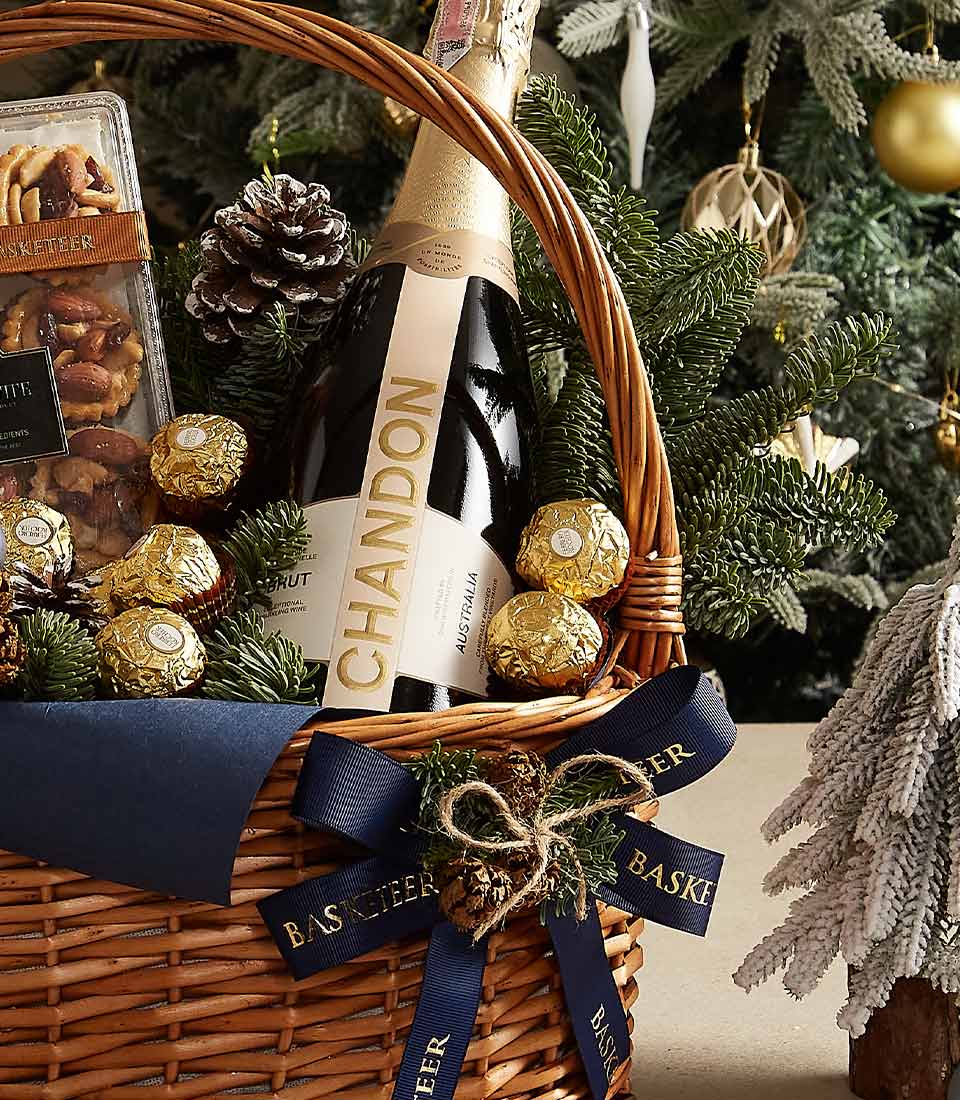 Champagne gift basket with Chandon sparkling wine, Ferrero Rocher chocolates, and festive holiday treats in woven wicker
