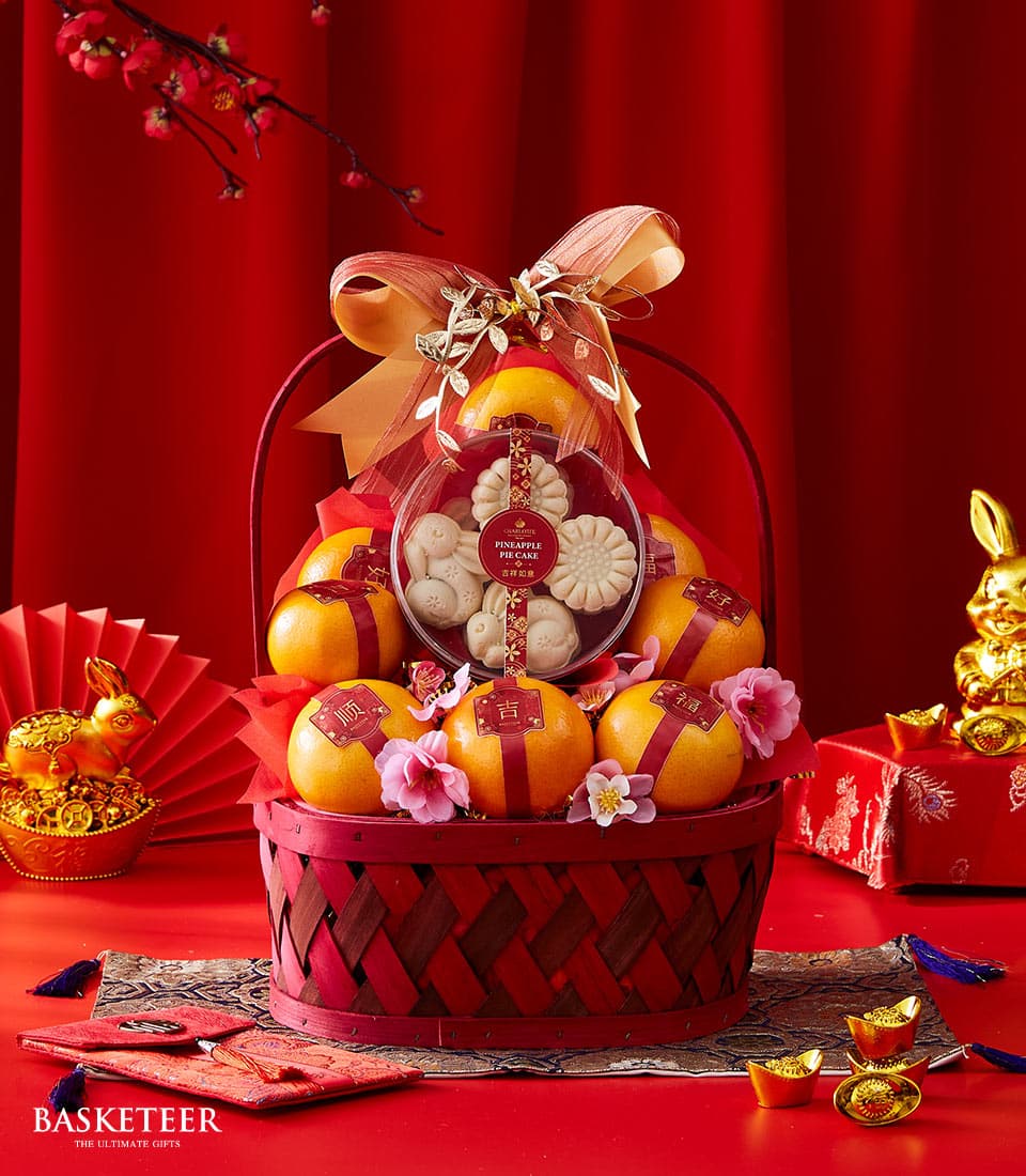 Festive red gift basket with mandarin oranges and pineapple cakes for Chinese New Year celebration