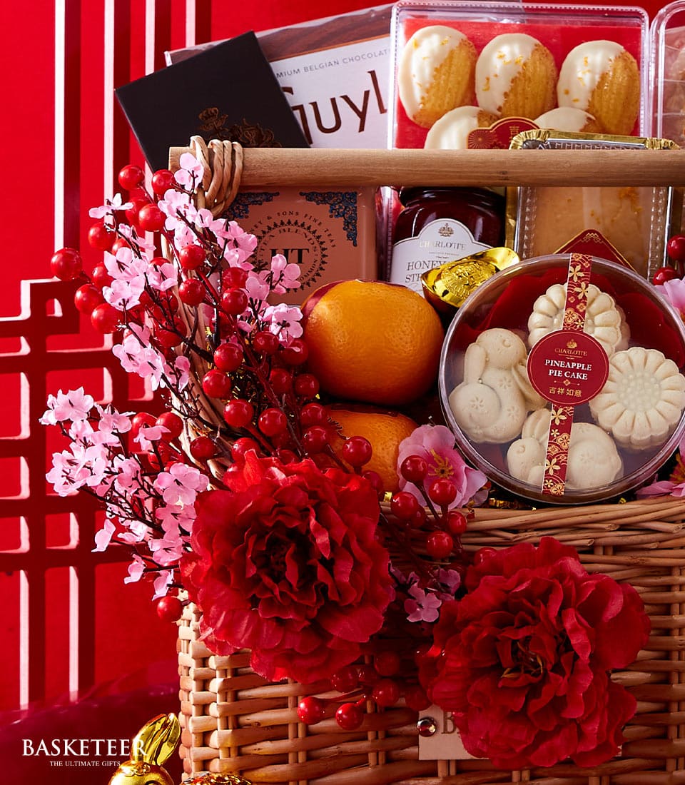 Lunar New Year wine and gourmet hamper with Belgian chocolate, honey sticks, and Charlotte pastries on red festive background