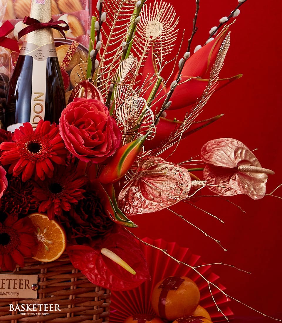 Luxury Chinese New Year gift basket with sparkling wine, red roses, gerberas, anthuriums, fresh oranges and artisan treats