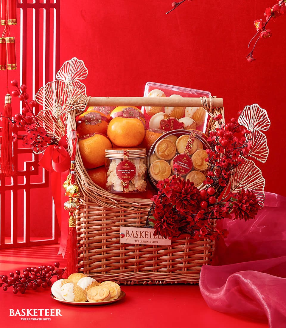 Festive Chinese New Year gift basket with fresh tangerines, almond and chocolate orange cookies, red dahlias, and gold