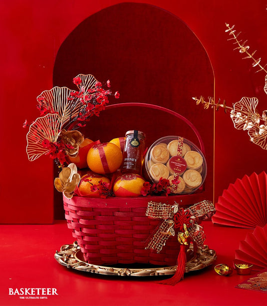 Luxury red and gold Chinese New Year gift basket with oranges, honey, almond cookies, and festive ornaments