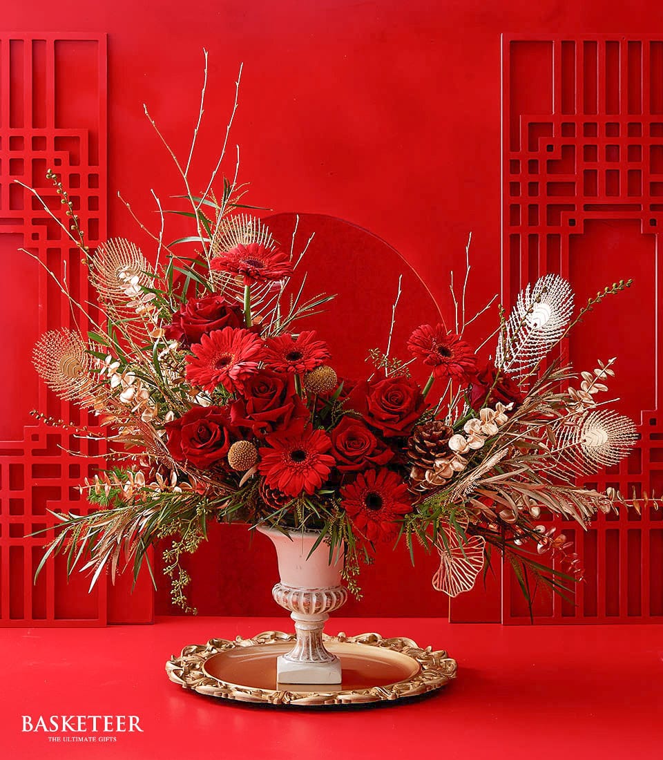 Deep red roses and gerbera daisies in white urn vase with gold accents, Lunar New Year centerpiece arrangement