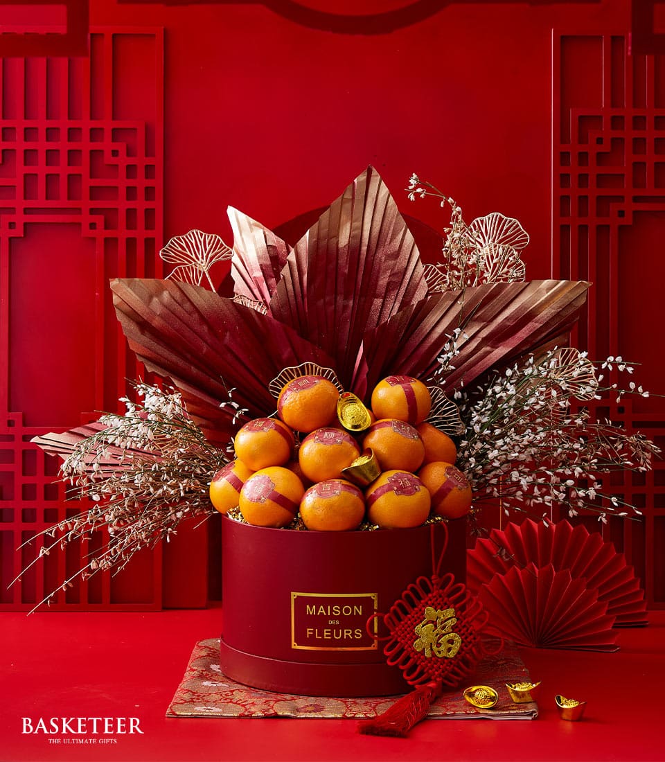 Luxe mandarin and flower arrangement with red and gold accents for Chinese New Year celebrations