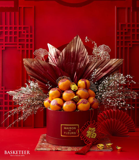 Luxe mandarin and flower arrangement with red and gold accents for Chinese New Year celebrations
