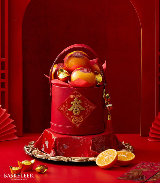 Elegant red mandarin gift box with gold fortune character, oranges, and prosperity ingots for Chinese New Year