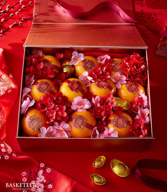 Red luxury gift box with nine auspicious oranges, red silk bands, gold characters, and festive florals for Chinese New Year