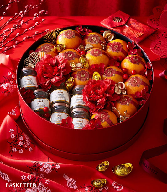 Red Lunar New Year gift box with mandarin oranges, premium bird's nest, gold ingots, and festive flowers