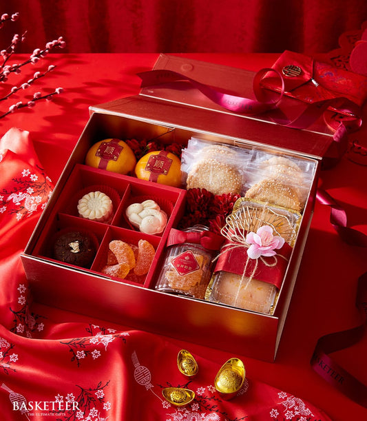Lunar Celebration premium treat box with sesame cookies, candied fruits, and artisan pastries on red silk with gold accents