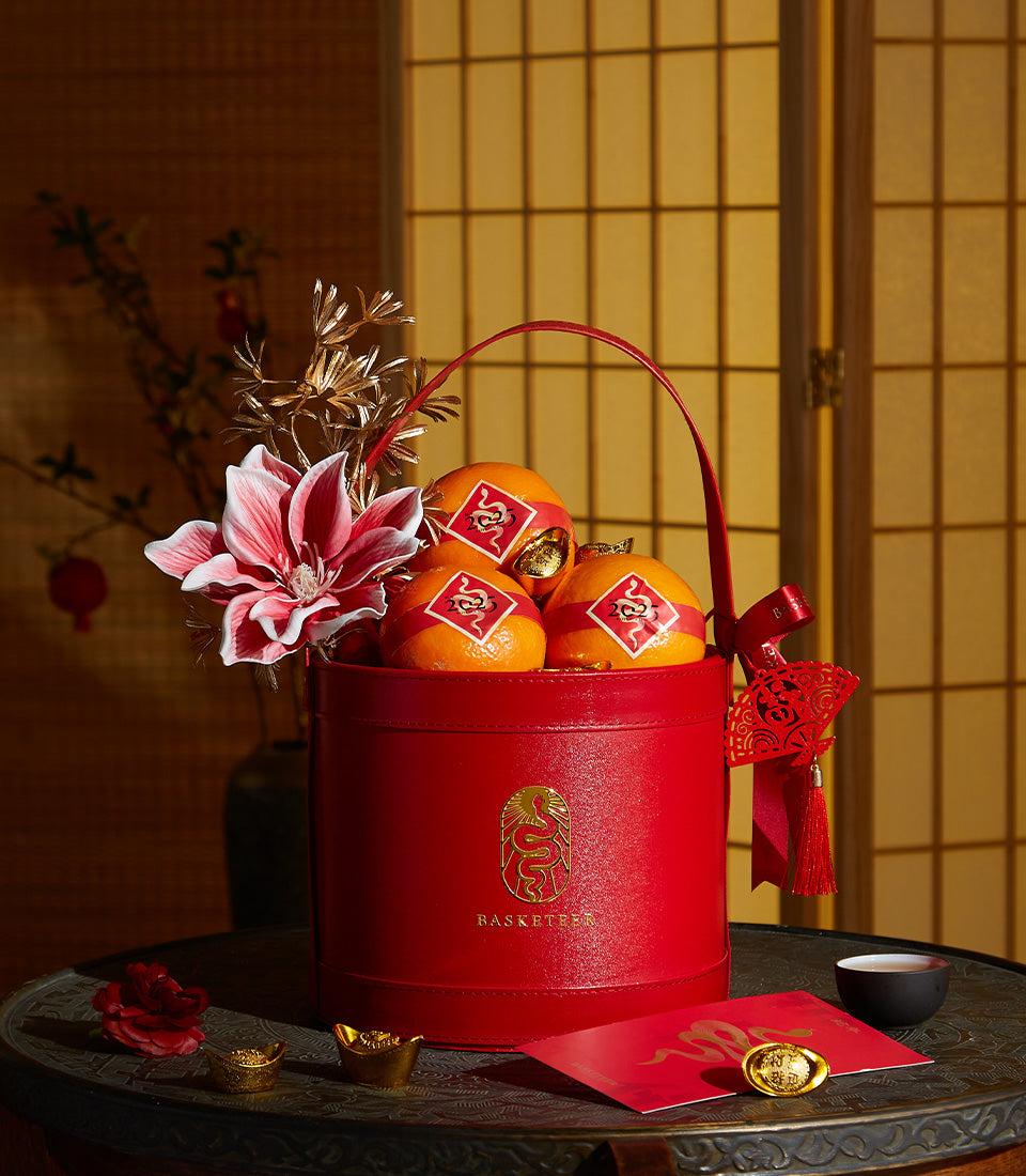 Basketeer luxury gift basket for Chinese New Year. Red gift box with oranges, gold accents, and festive decor. Premium hamper delivery Thailand.
