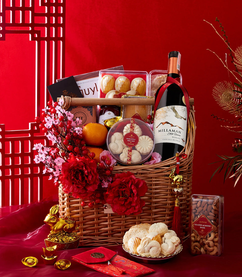 Luxury Chinese New Year gift basket with red wine, chocolates, pineapple cakes, fresh oranges, and festive red envelopes on