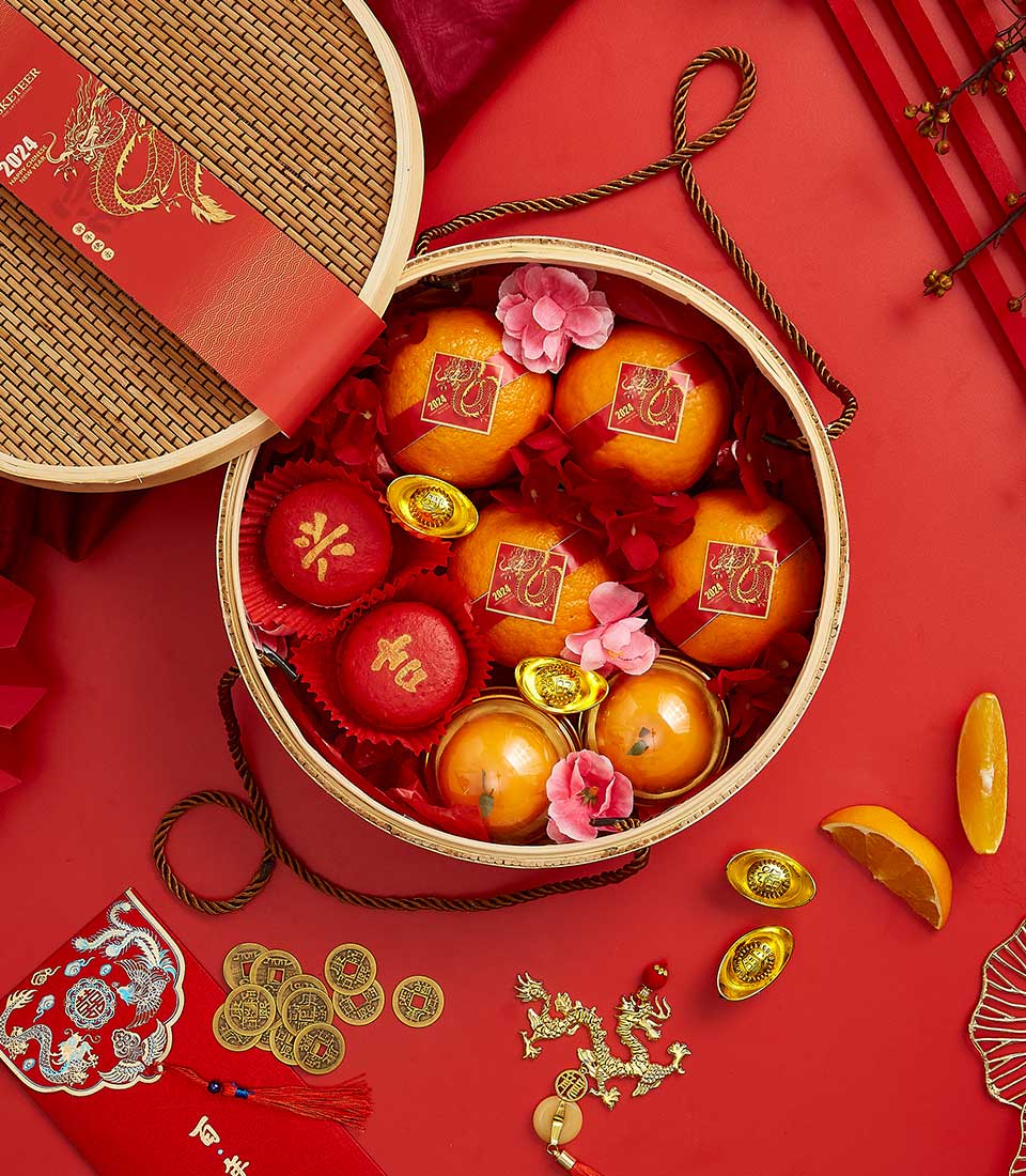 Basketeer CNY gift of mandarin oranges and festive sweets in a round woven hamper. Premium hamper delivery in Thailand.