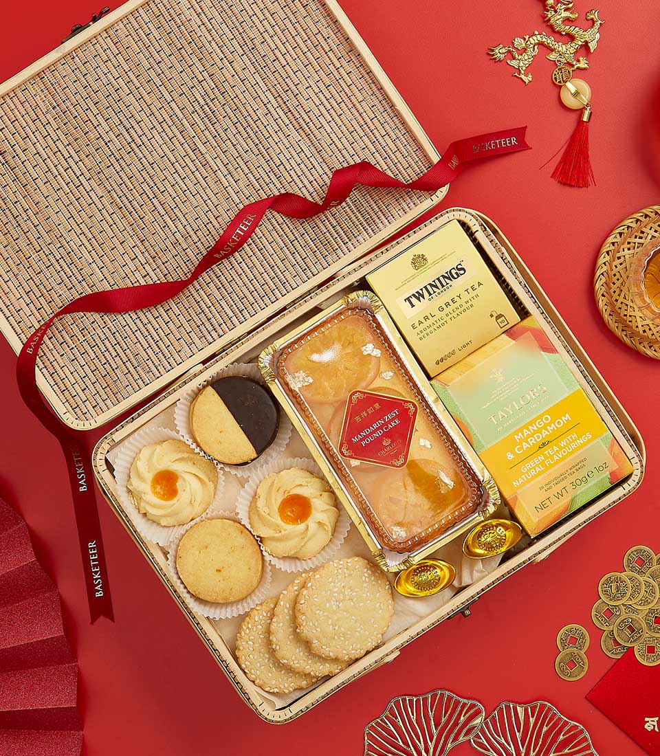 Lunar New Year luxury gift basket with shortbread cookies, citrus pound cake, artisan teas, and festive gold accents on red