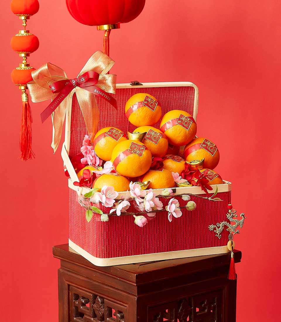 Red woven mandarin gift basket with gold ribbon bow, Chinese lanterns, and dragon charm for Lunar New Year