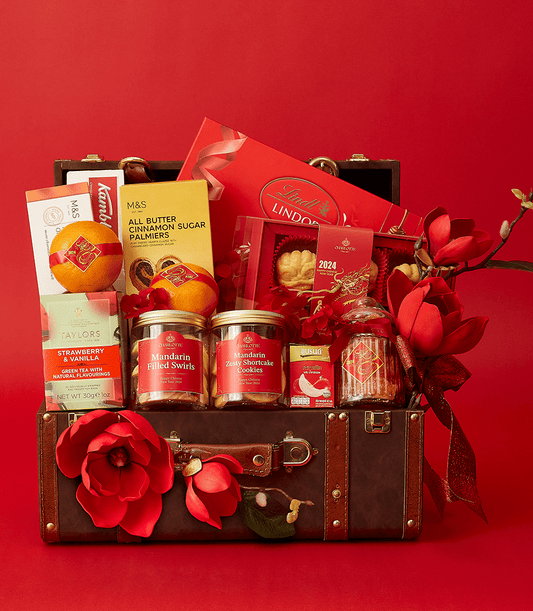 Lunar New Year luxury hamper in vintage suitcase with Lindt chocolates, premium biscuits, mandarin tea, and red gold festive