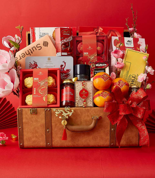 Luxury Chinese New Year hamper in brown leather suitcase with gold dragon charm, filled with premium gourmet treats, teas,