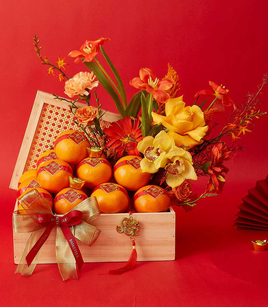 Mandarin oranges and red roses in woven rattan box with gold accents for Chinese New Year