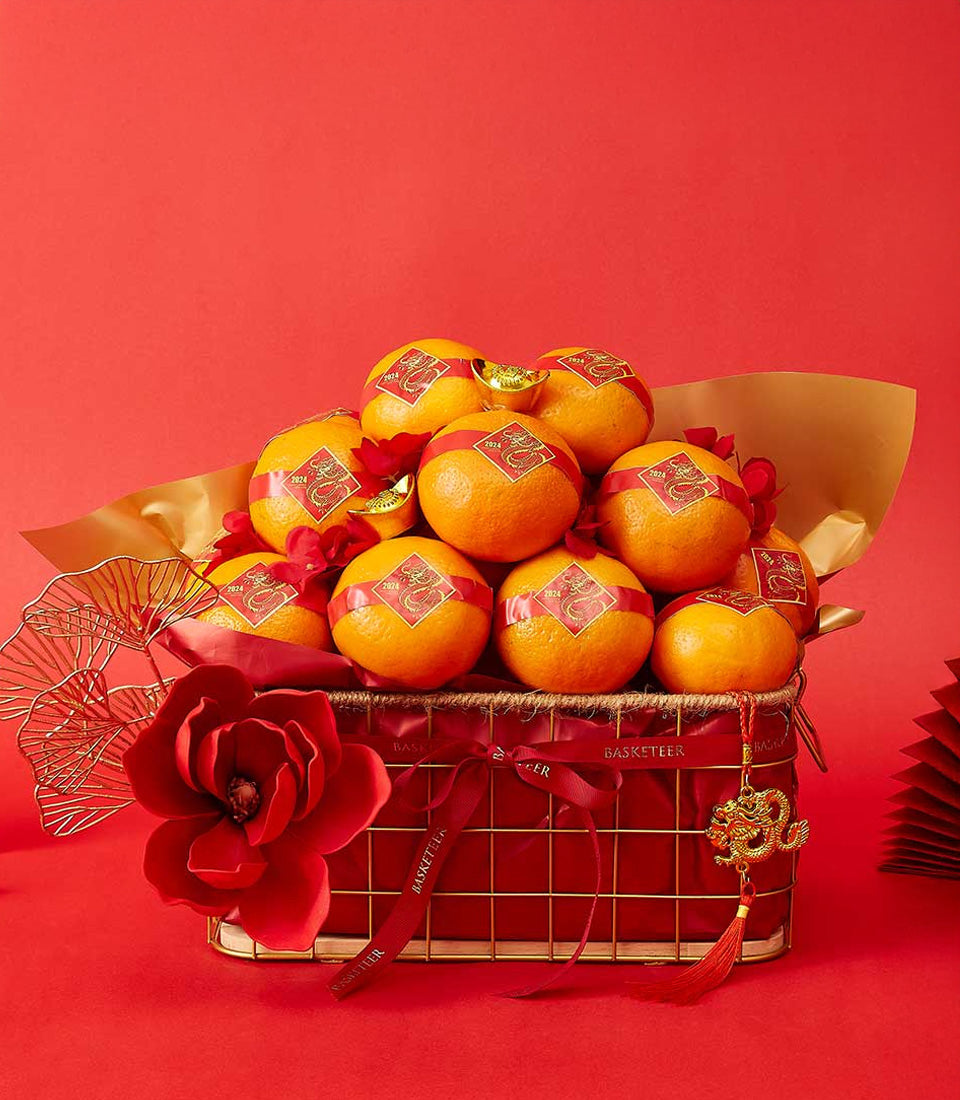 Gold wire basket with red fabric, mandarin oranges, gold ingots, and dragon charms for Chinese New Year celebration