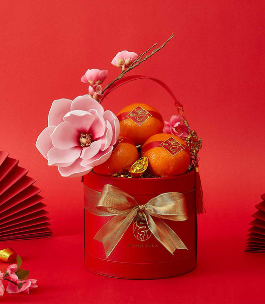 CNY orange luxury gift box with dragon stickers, gold accents, and pink flowers on red festive background