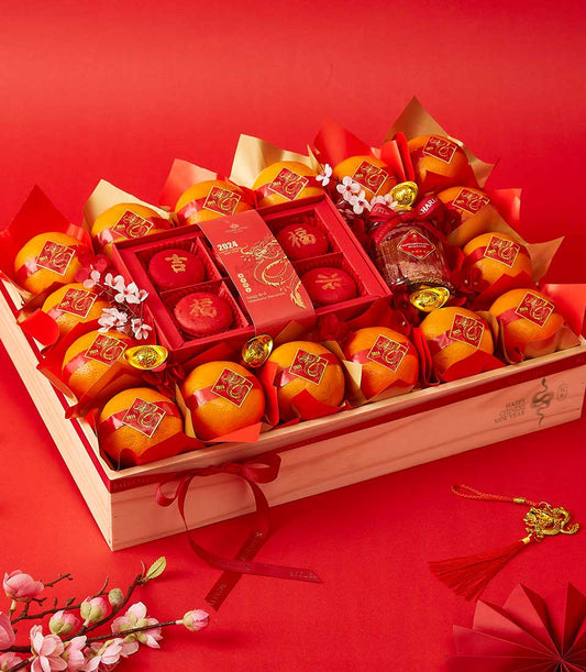 Premium lunar orange treasures gift crate with wrapped mandarins, fortune macarons, and gold accents for Chinese New Year