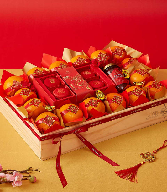 Lunar Citrus Splendor wooden crate with gold-wrapped oranges, red macarons, marmalade, and dragon charms for Chinese New Year