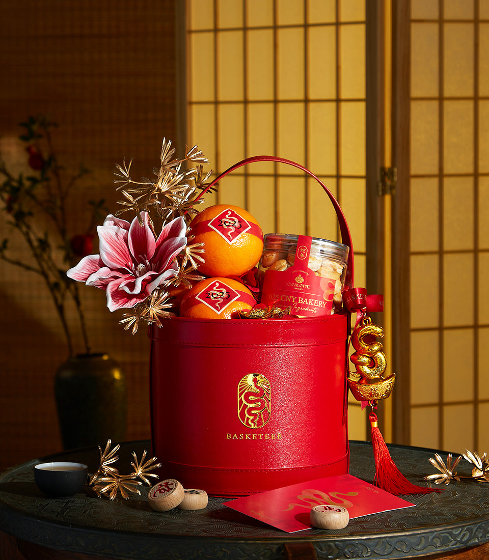 Basketeer Bangkok: Festive red gift hamper with oranges, bakery treats, and a lucky charm. Premium same-day gift delivery in Thailand.