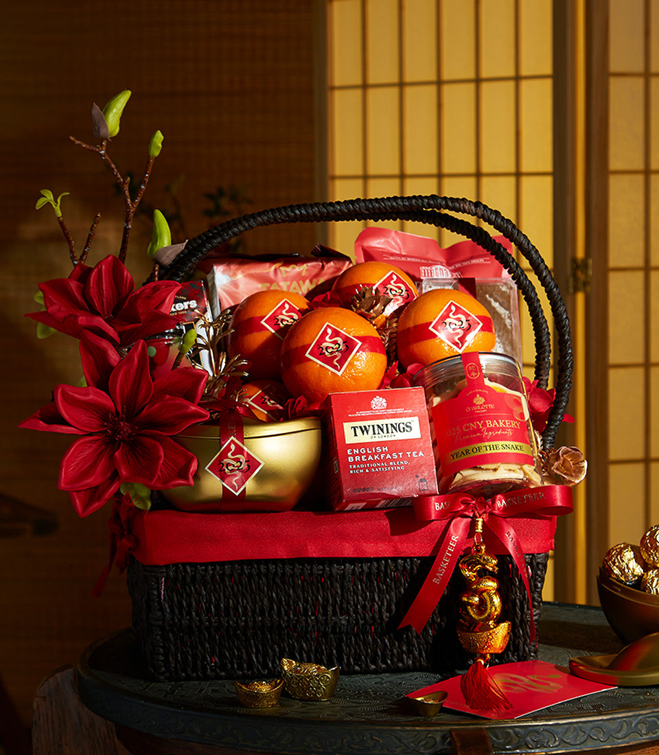Luxury black and red Chinese New Year hamper with mandarins, tea, and golden accents in woven basket