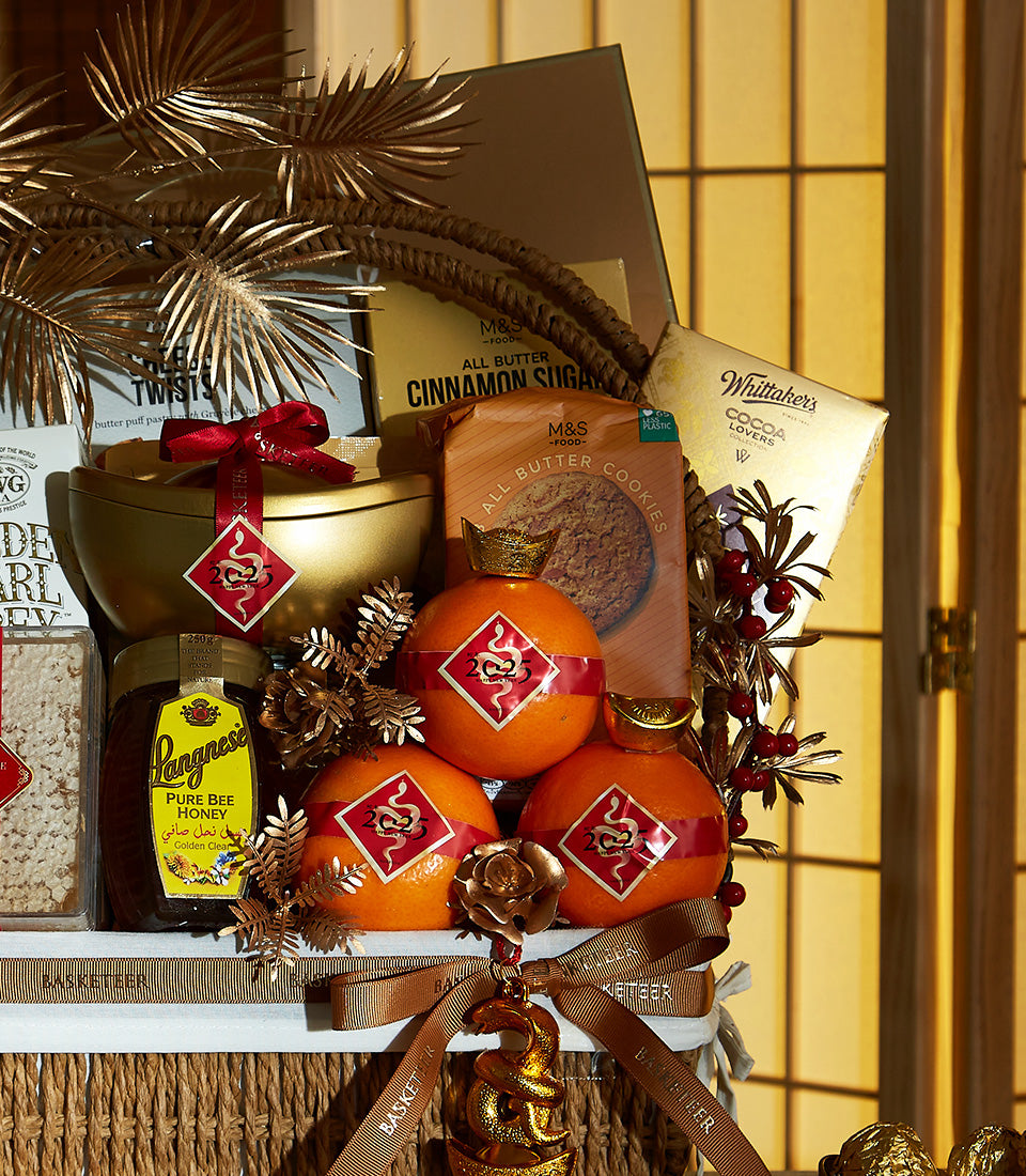 Opulent Chinese New Year gift basket with M&S butter cookies, Whittaker's chocolate, honey, crowned oranges, and golden