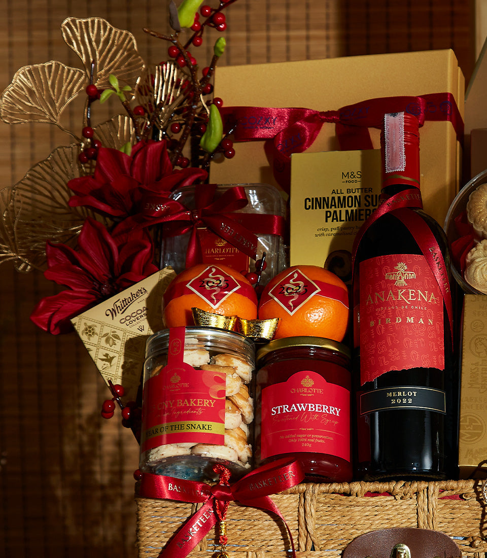 Lunar New Year gift hamper with Merlot wine, gourmet treats, and festive red and gold decor in wicker basket
