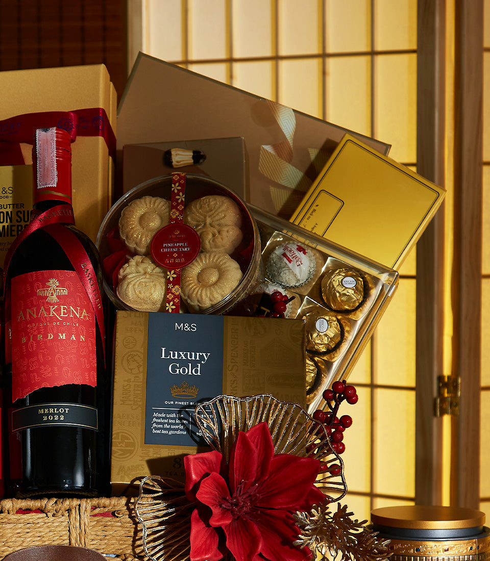 Lunar New Year luxury gift hamper with Merlot wine, pineapple cheese tarts, gourmet chocolates, and festive red poinsettia