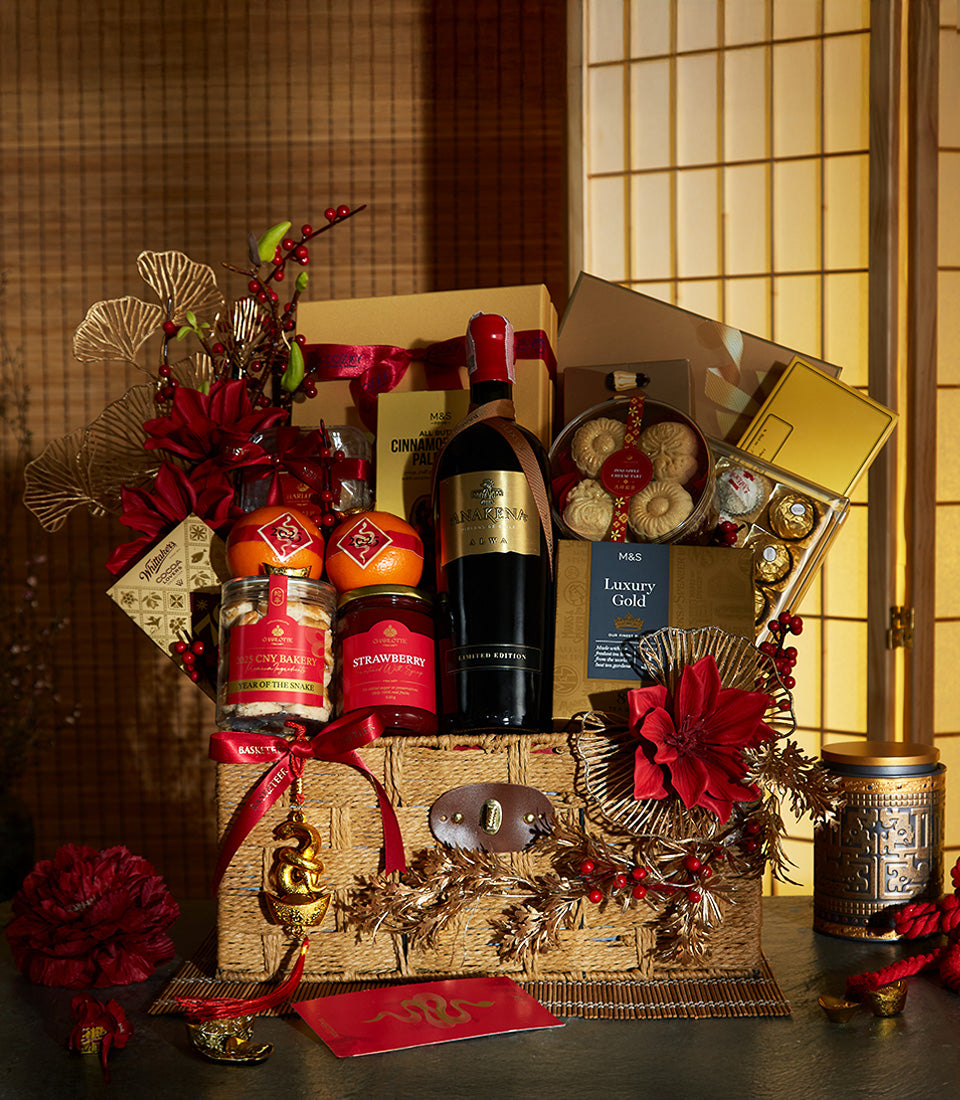 Luxury Chinese New Year wine gift basket with red wine, gourmet preserves, chocolates, and gold accents in woven straw