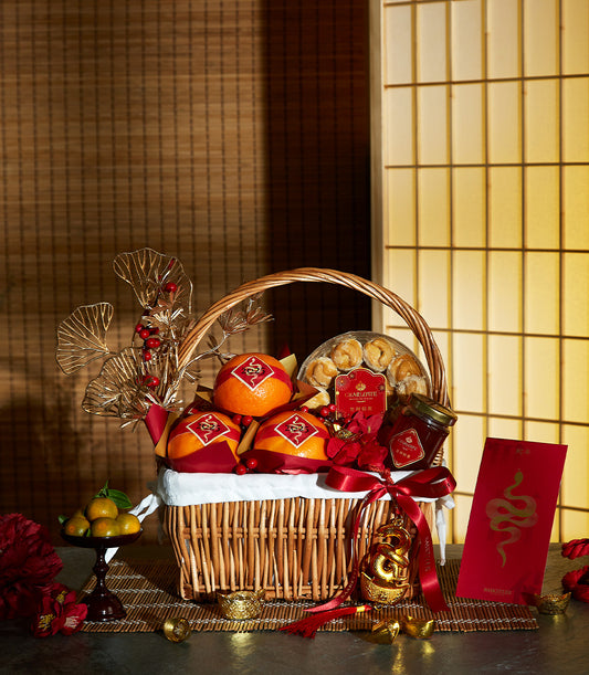 Festive Harmony Mandarin basket with red-wrapped oranges, pastries, and gold snake ornaments for Chinese New Year