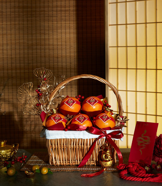 Festive Mandarin Basket with red and gold wrapping, wicker basket, red ribbons, and lucky charm for Chinese New Year