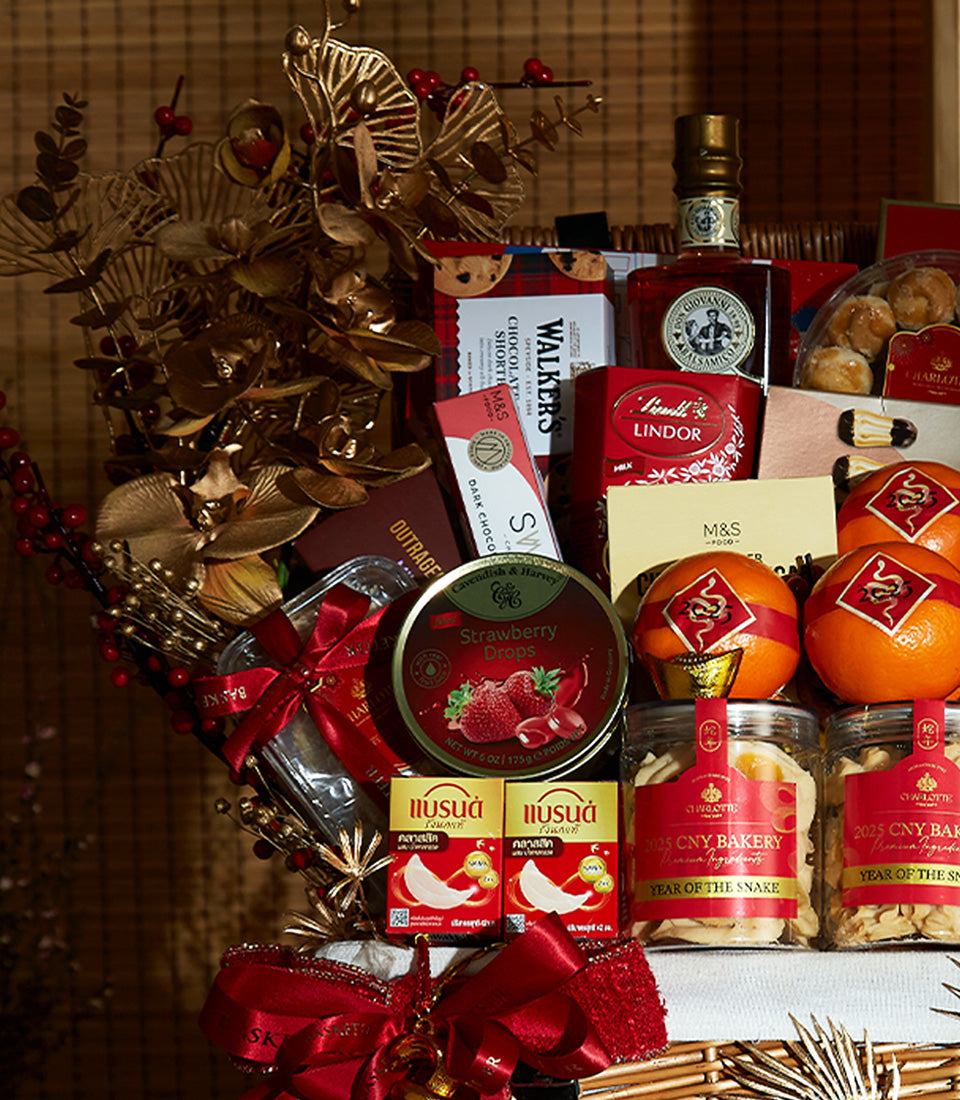 Lunar New Year wine gift basket with red wine, gourmet chocolates, and festive gold leaf decorations