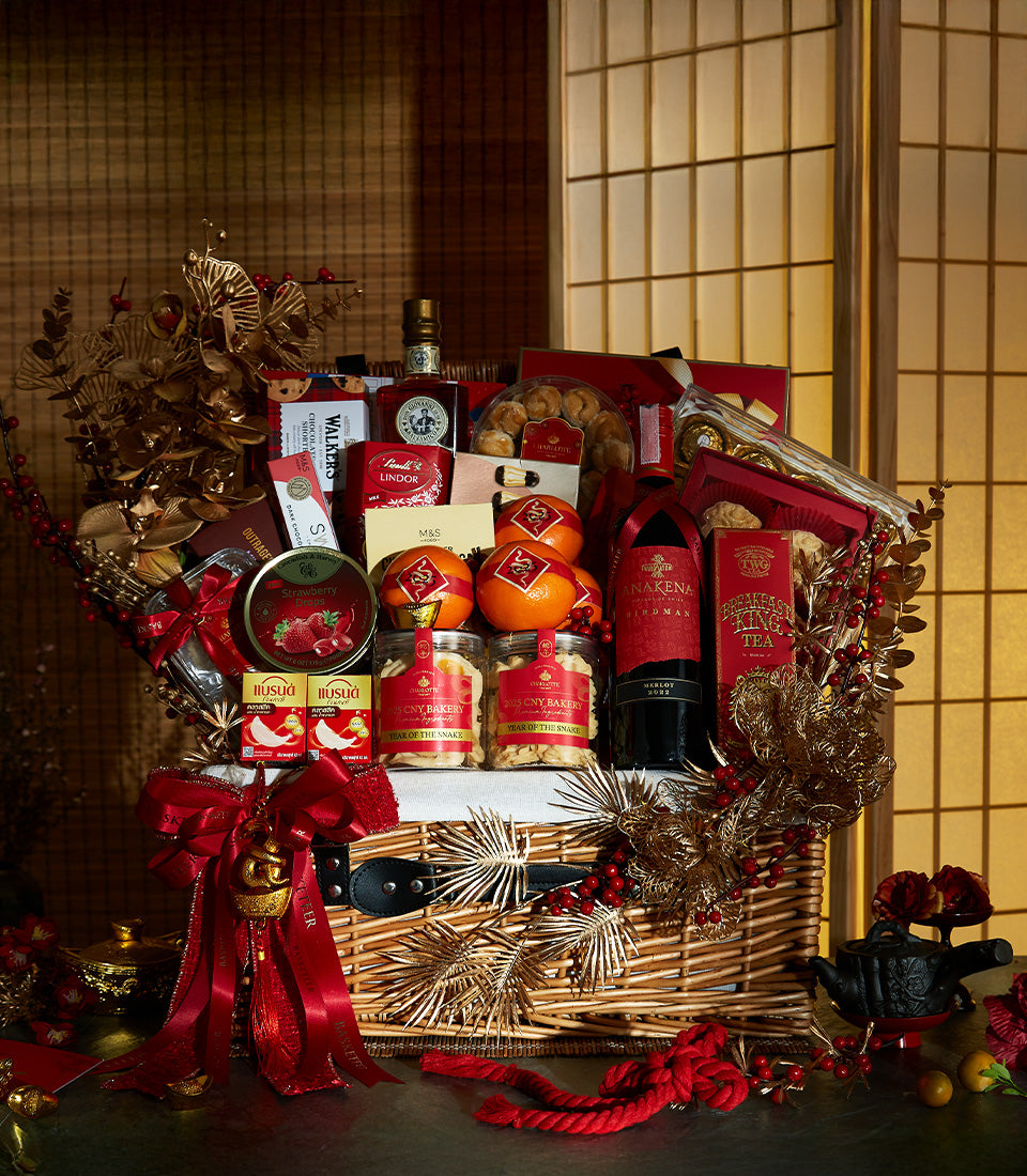 Luxury Lunar New Year gift hamper with red wine, gourmet chocolates, and festive gold accents in wicker basket
