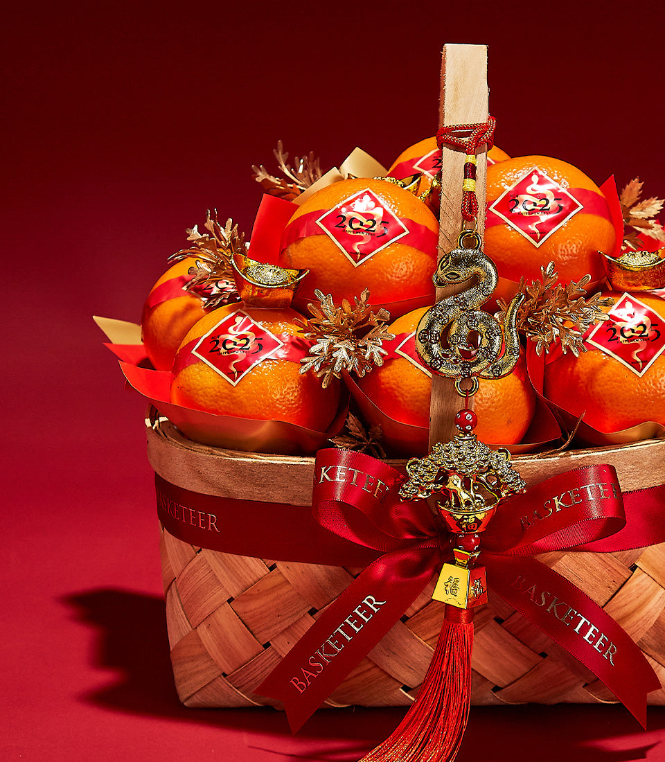 Prosperity Mandarin gift basket with fresh oranges, red satin ribbon, golden dragon ornament, and traditional luck symbols