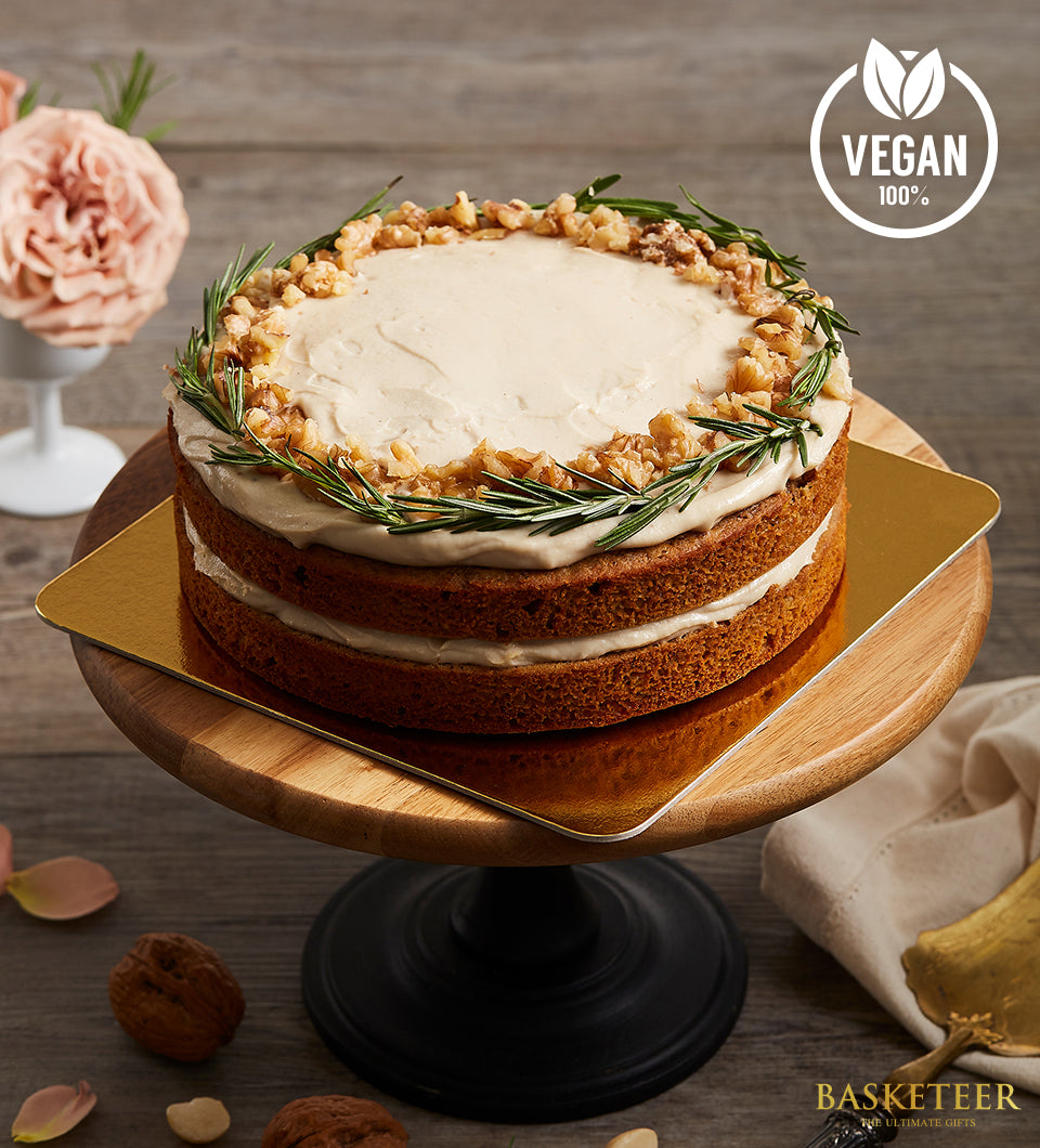 Vegan carrot cake with walnut and rosemary topping on wooden stand, artisan birthday celebration cake
