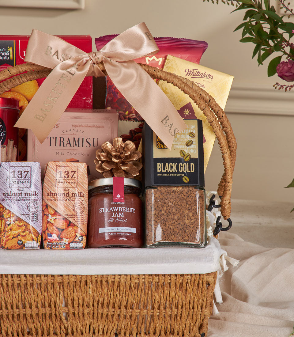 Woven natural basket filled with premium coffee, plant-based milk, strawberry jam, and tiramisu chocolate for New Year