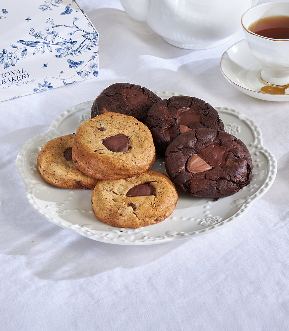 Classic chocolate chip and double choco chip cookies on ornate plate with gift box and tea service